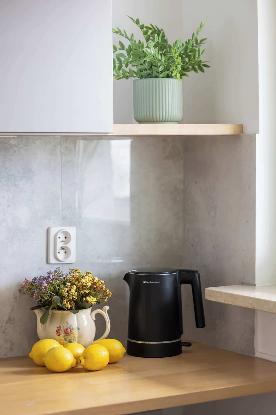 A close-up of the kitchen counter with a fruit, and decorative shelves. Small details add a cozy touch.