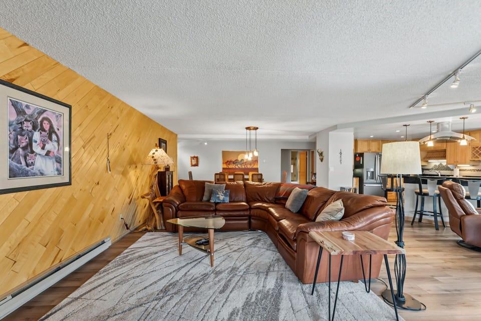 Sink into plush leather seating in this warm, open-concept living space where rustic wood accents meet modern comfort, perfect for unwinding after your mountain adventures.