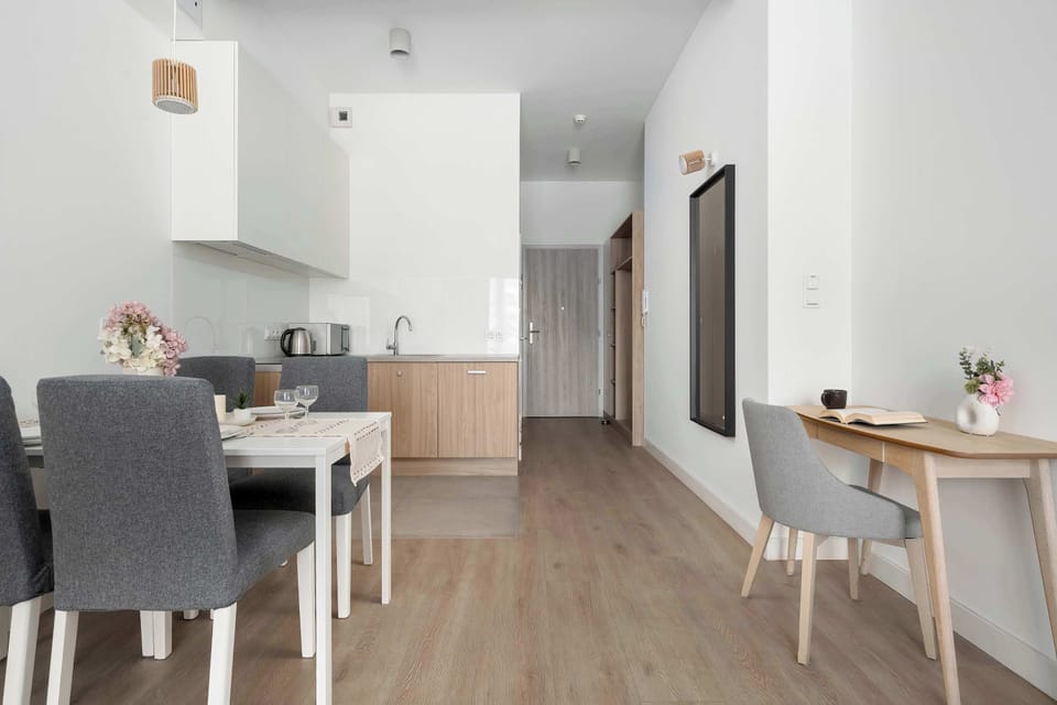 A broader interior view connects the dining area with the entrance and kitchen beyond. Open floor space enhances the sense of flow.
