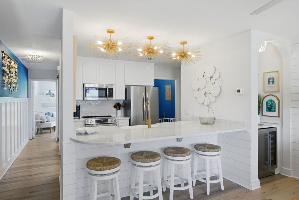 North Lost Key Landing B2- Prepare your favorite meals in this stunning chef's kitchen, featuring gleaming marble countertops, modern appliances, and stylish gold starburst lighting that creates the perfect ambiance for cooking and entertaining.