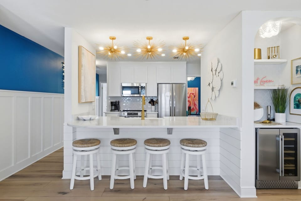 North Lost Key Landing B2- Gather around this sleek breakfast bar where modern elegance meets coastal charm. Golden starburst fixtures illuminate your morning coffee .