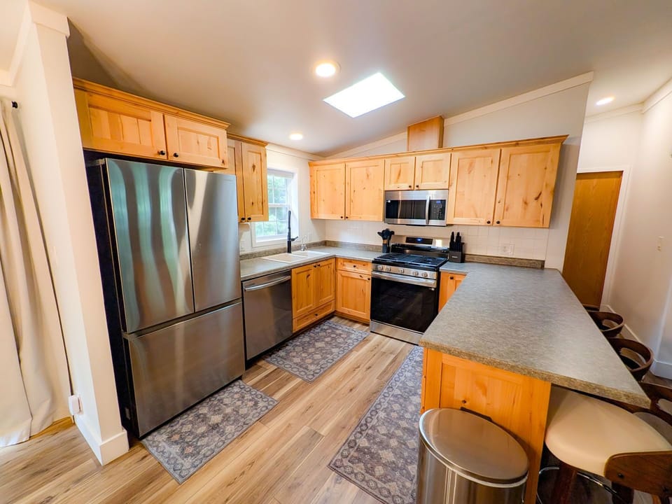 Bright updated kitchen with stainless appliances and breakfast bar seating