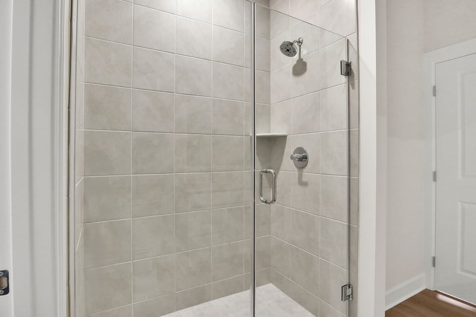 Walk-in shower — large-format tile, built-in shelf, chrome fixtures
