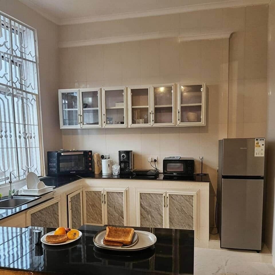  Bright and functional kitchen with a fridge, microwave, blender, toaster, and more. Everything you need to prepare meals and feel at home, with natural light pouring in through large windows.
