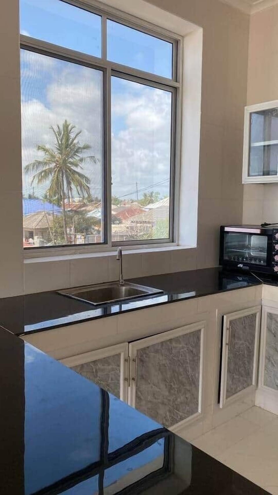 Enjoy a kitchen view like no other  prep meals with palm trees and ocean breeze right outside your window. Bright, airy space with modern countertop and essential appliances for a comfortable stay.

