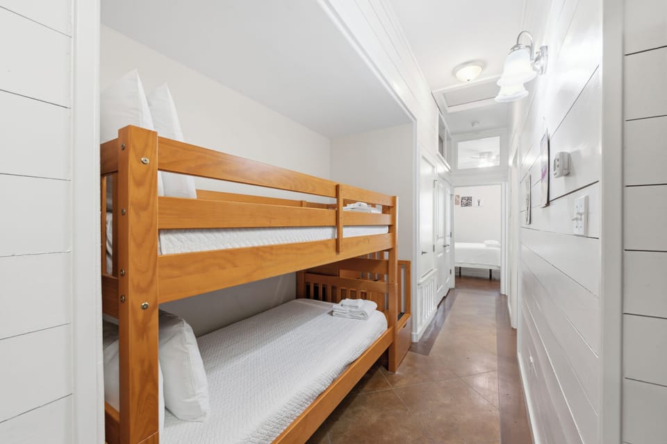 Your cozy bunk room is thoughtfully designed with warm wood tones and crisp white linens, perfect for kids or friends sharing memories in this bright, welcoming space.