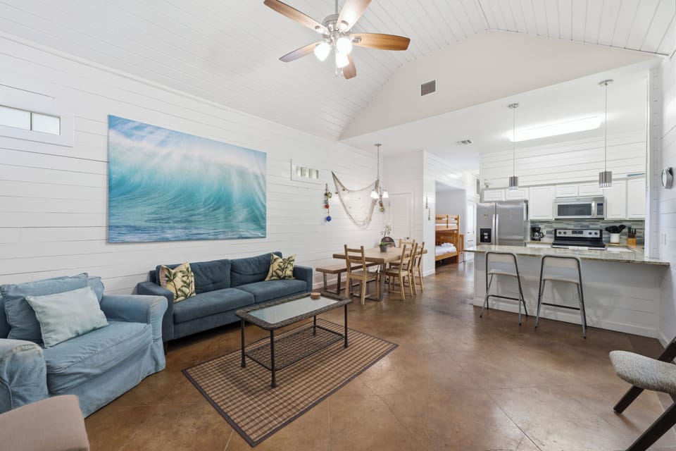 Unwind in this airy open-concept space where coastal charm meets modern comfort. Soaring vaulted ceilings and bright shiplap walls invite you to relax, cook, and gather with loved ones in effortless style.