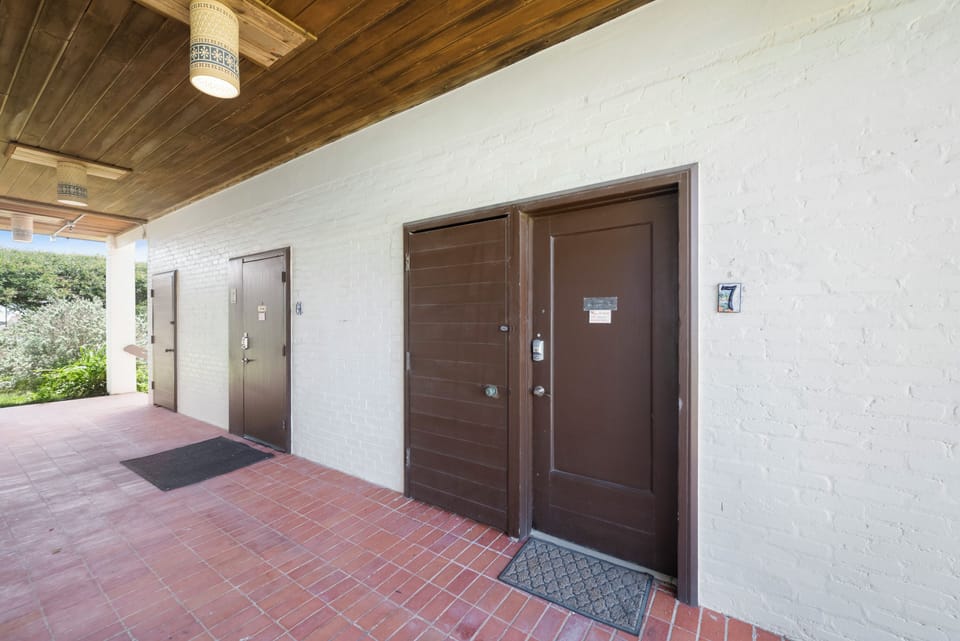 Property entrance with unit number 7 marker and brick pathway.