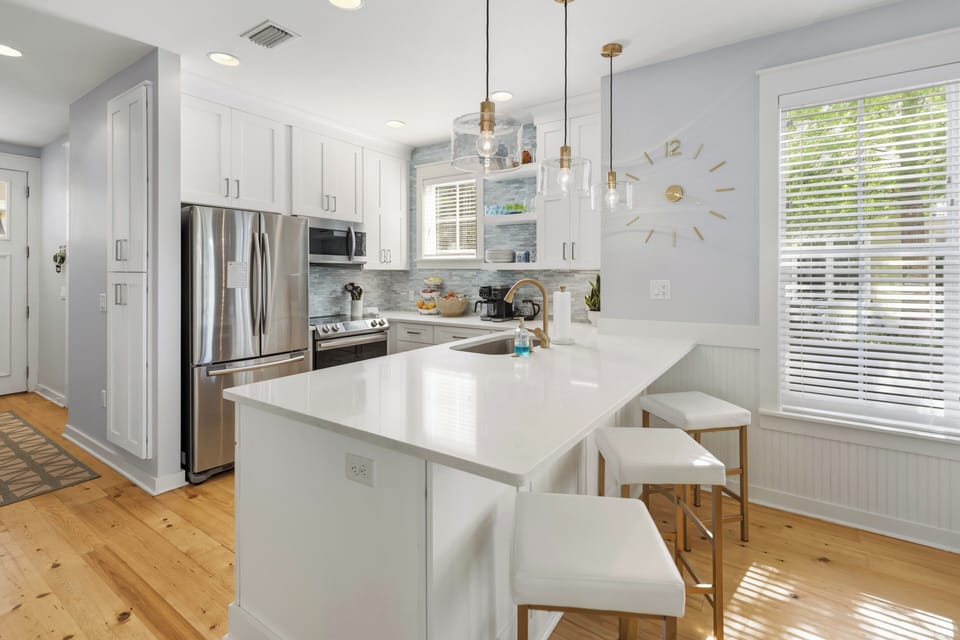 Step into your bright, fully-equipped kitchen where morning coffee and home-cooked meals feel effortless. Sunlight streams through large windows, illuminating sleek countertops and stainless appliances—your culinary retreat awaits.