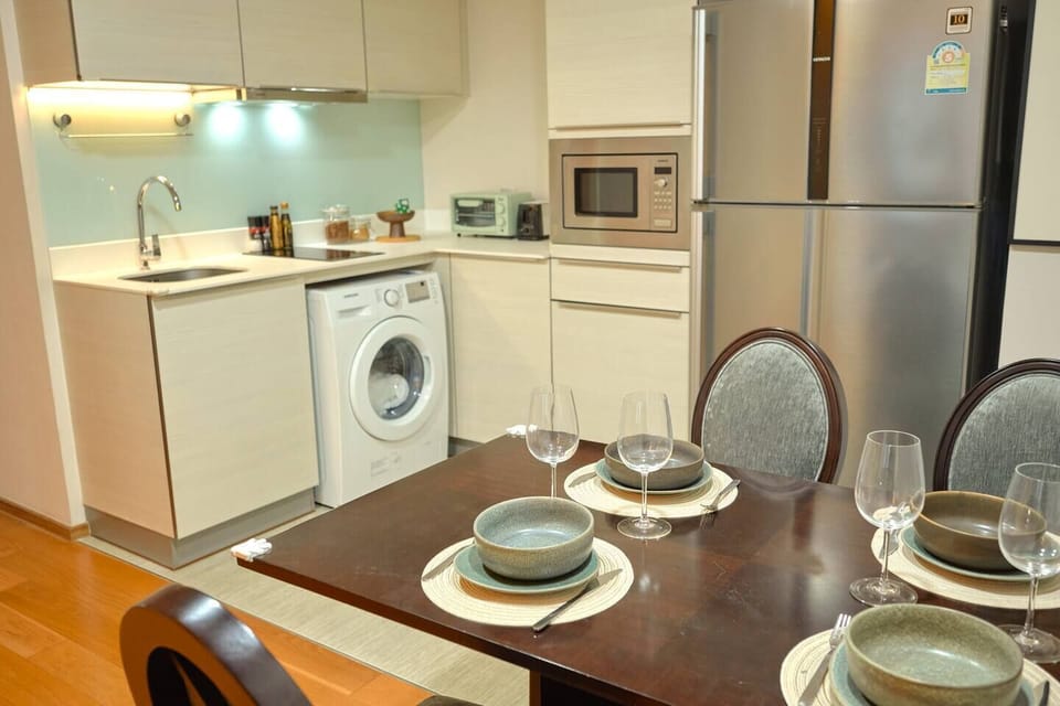 【Dining】Our fully equipped kitchen includes pots, pans, cutlery, and a washing machine—perfect for longer stays and hosting friends. The adjacent dining area has a large table and comfy chairs, creating an ideal space for meals and gatherings.