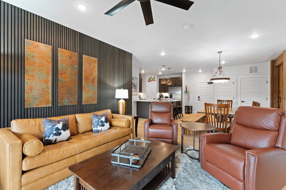 The living room offers a programmable electric fireplace, mounted Smart TV, sleeper sofa, and access to the private balcony.