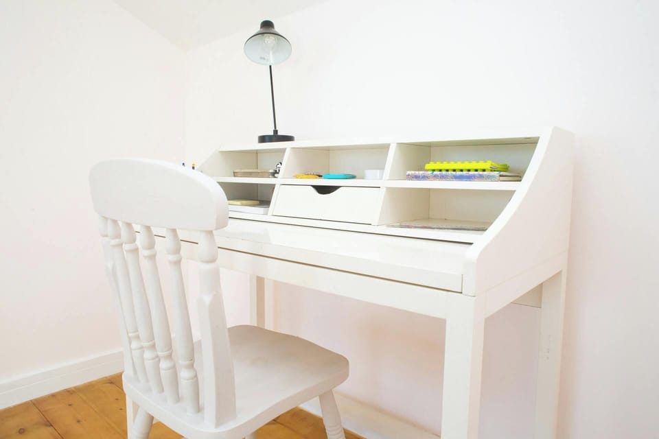 White writing desk with built-in shelves and a white chair