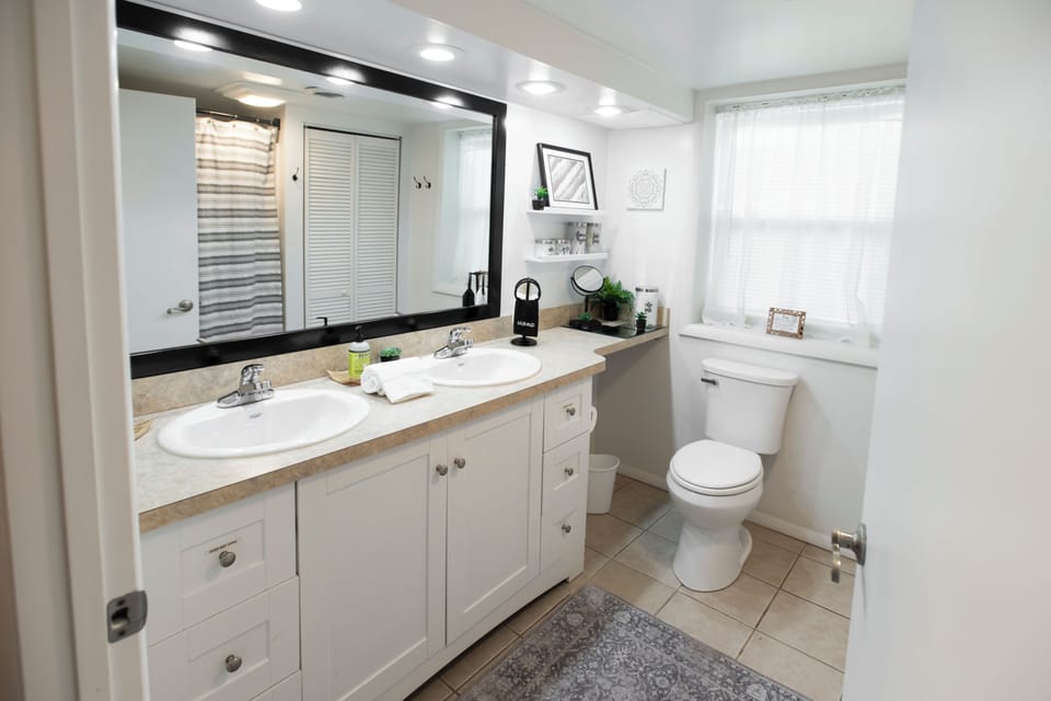 Bright bathroom with double vanity, natural light, and ample space