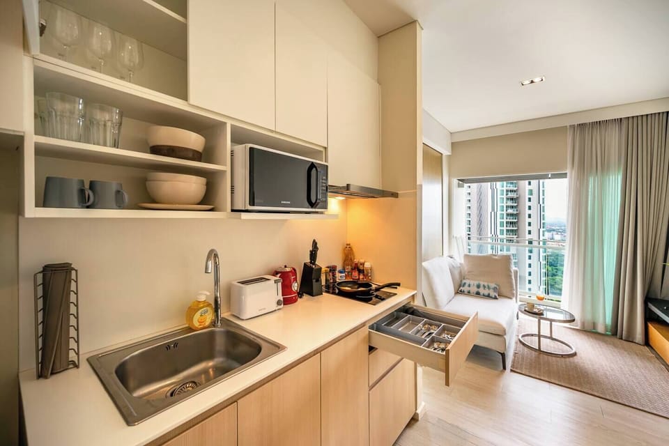 Full kitchen fitted with electric stove, hood ,microwave and cooking utensils
