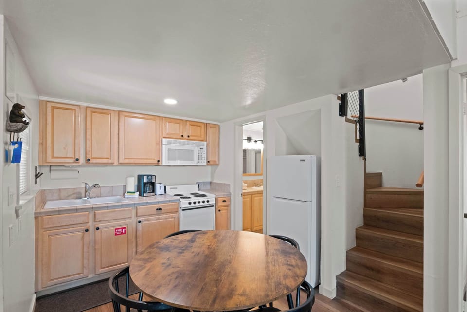 Compact kitchen with wooden cabinets and dining.