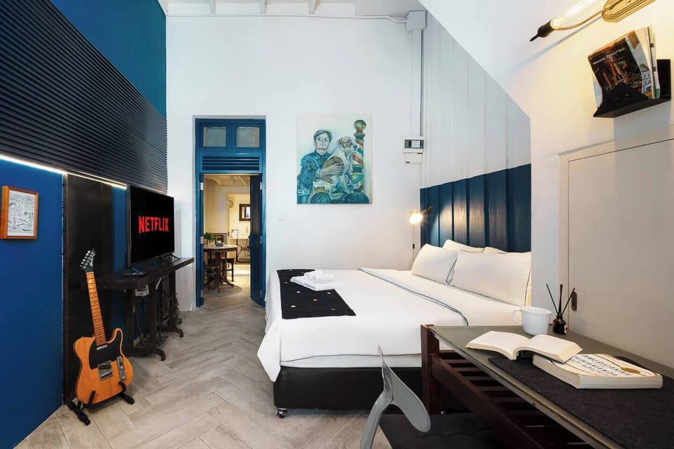 The king-size bed offers comfort and a perfect view of the smart TV. With 500 Mbps WiFi streaming is smooth and easy. A door provides direct access to the bathroom and also connects to the next bedroom, making it convenient to move between spaces.