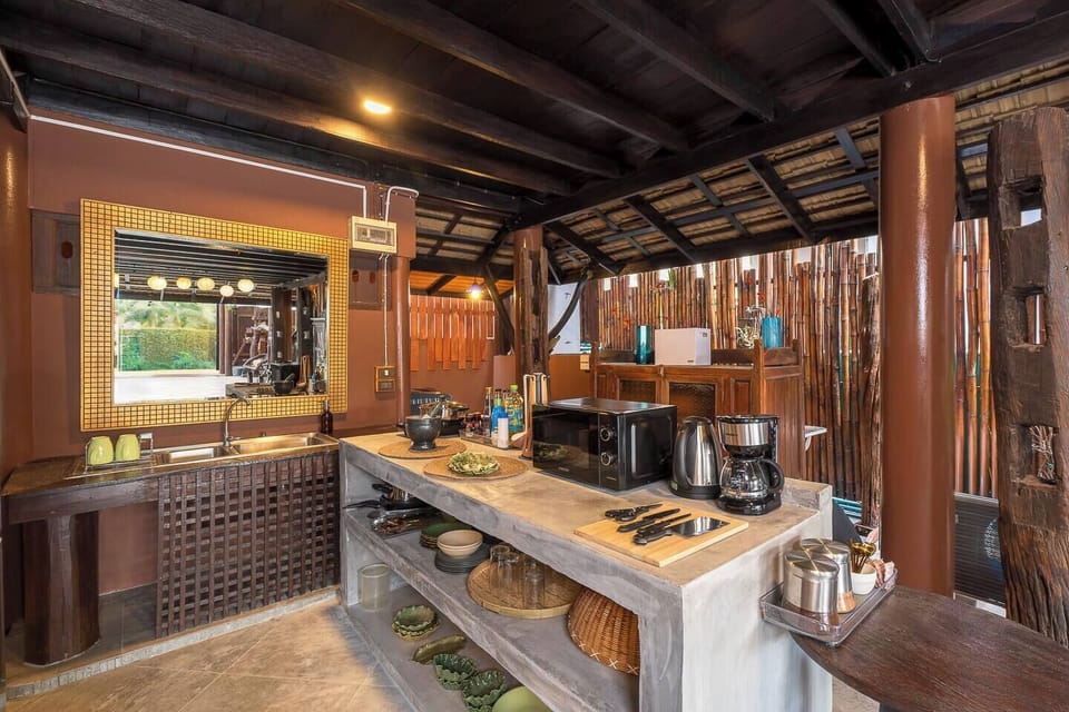 【Kitchen】Concrete Thai-style open kitchen with a fridge, stove, microwave, utensils, and plates for meal prep, plus a washing machine to keep your clothes fresh. There are wine glasses for celebrating your vacay together.