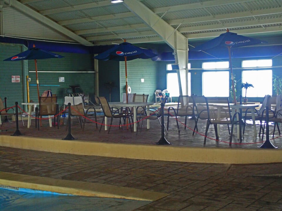 Lounge poolside with shaded tables for easy breaks.