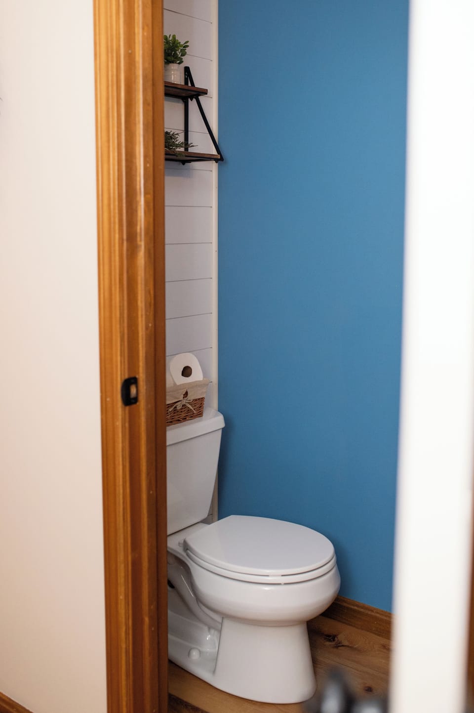 Charming half bath with bold blue wall and stylish rustic touches