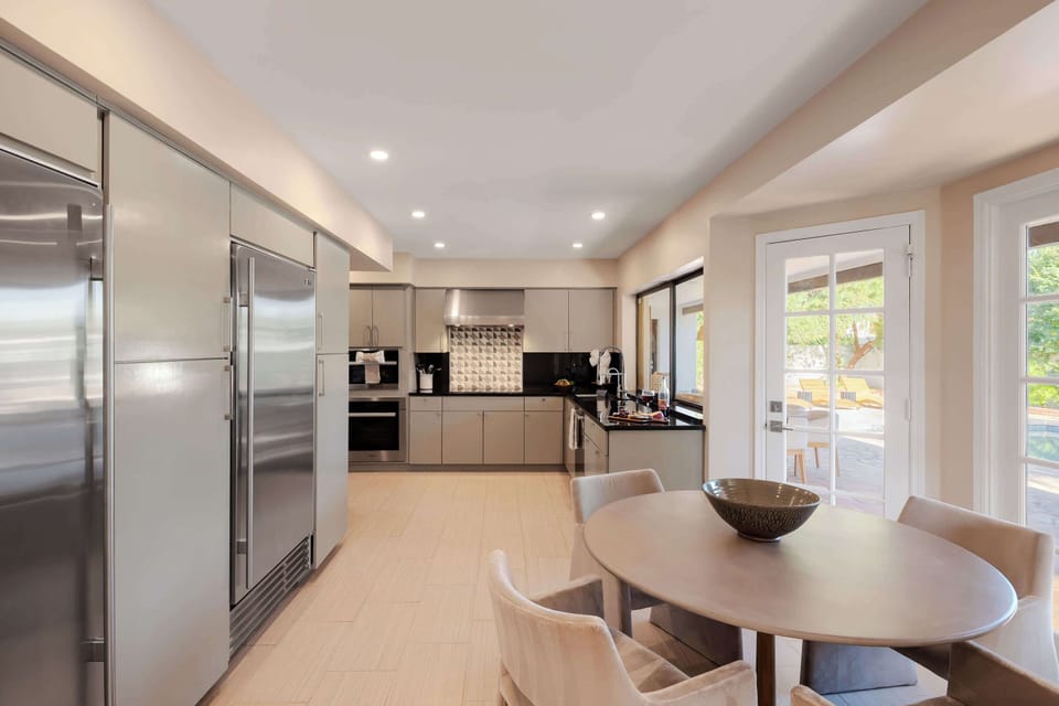 Modern chef’s kitchen featuring premium appliances, sleek cabinetry, and a bright dining nook, offering a stylish space to prepare and enjoy your favorite meals.