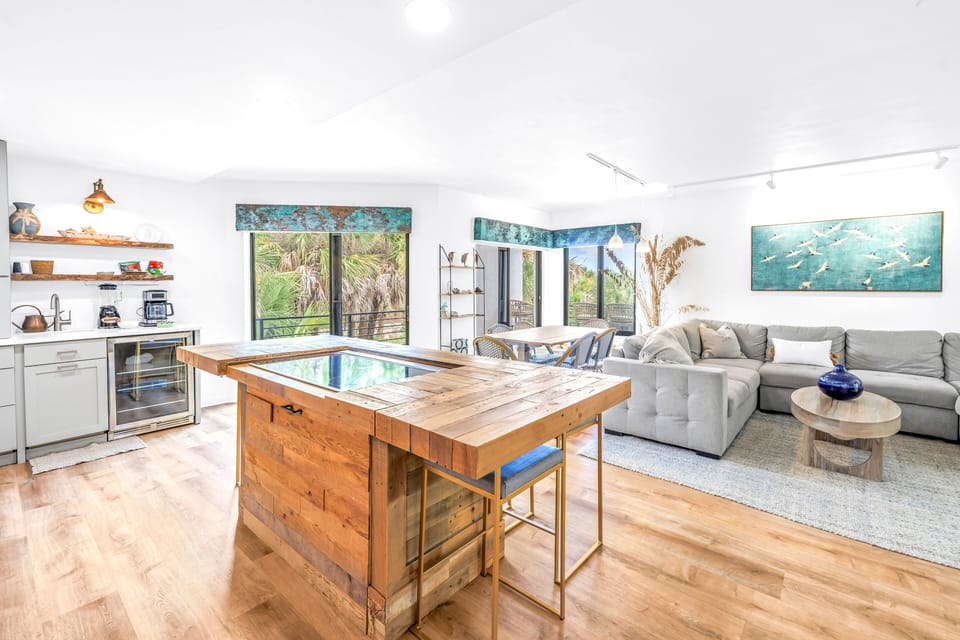 Kitchen area leading to living with tropical view.