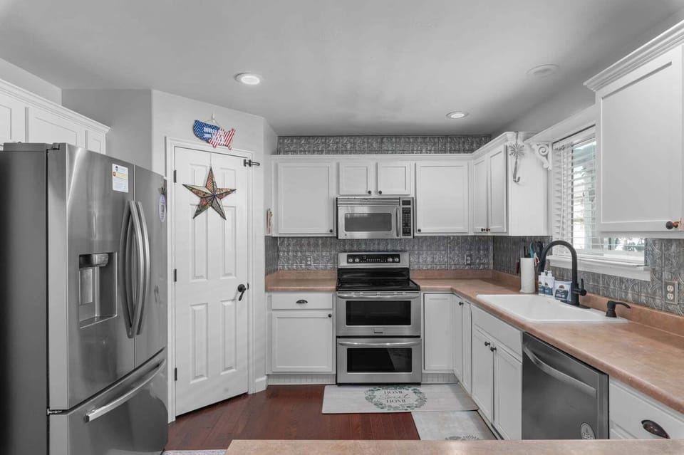 Full kitchen with stainless steel fridge, double oven range, and generous counter space