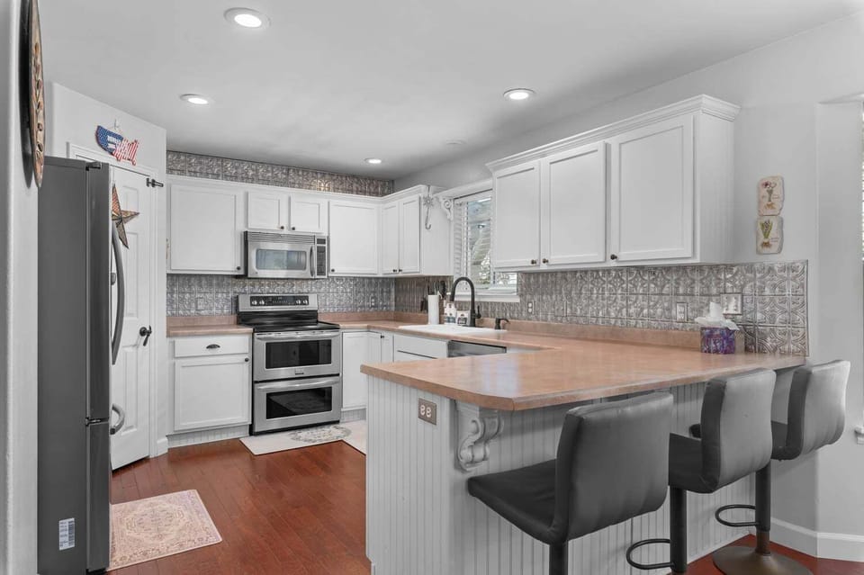 Chef's kitchen with stainless steel appliances, double oven, and butcher block island