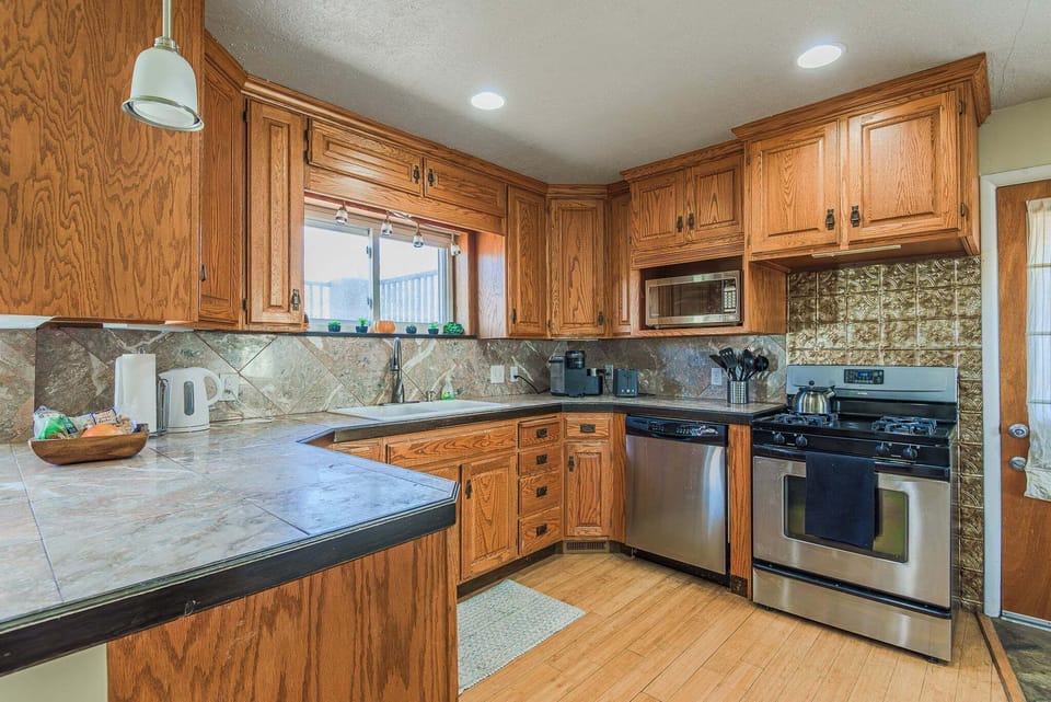 Fully equipped kitchen with granite countertops, gas range, and stainless steel appliances.