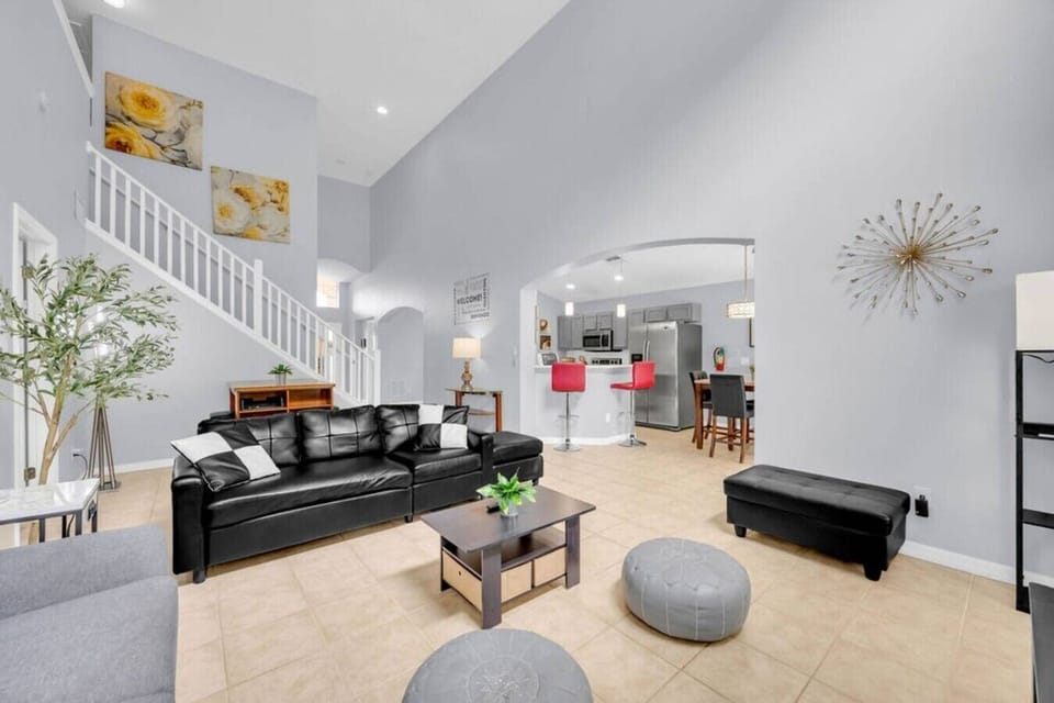 Spacious open-plan living & dining area w/ high ceilings & a stylish staircase.
