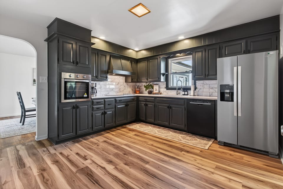Modern chef’s kitchen with dark cabinets, stainless appliances, and ample space