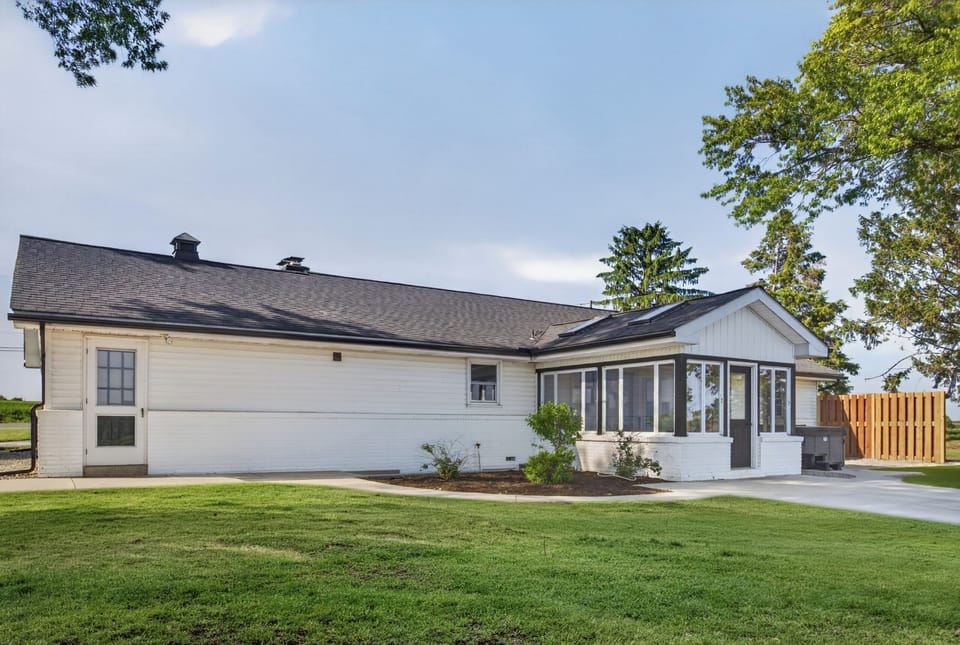 Charming home with sunroom, spacious lawn, and peaceful outdoor setting