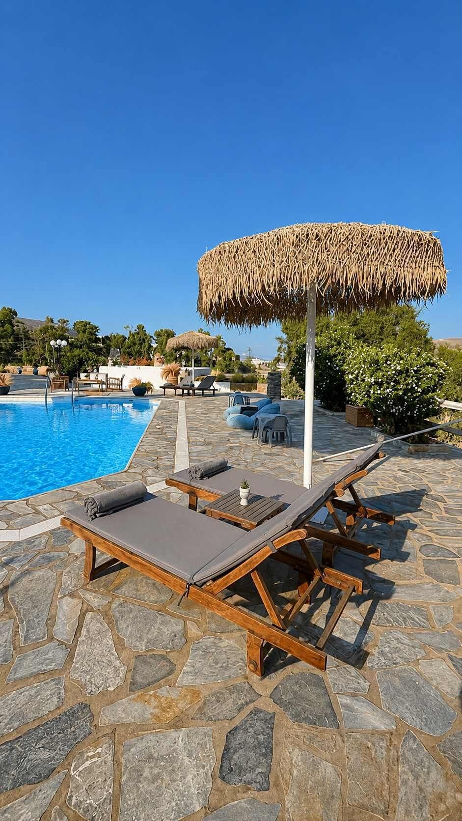 Poolside Sunbeds under Traditional Straw Umbrella