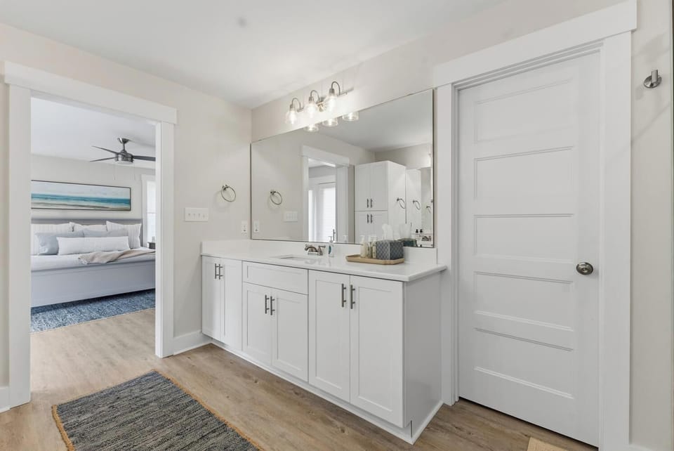 Your private ensuite bathroom features a spacious double vanity with bright lighting, ample storage, and direct access to your inviting bedroom just beyond.