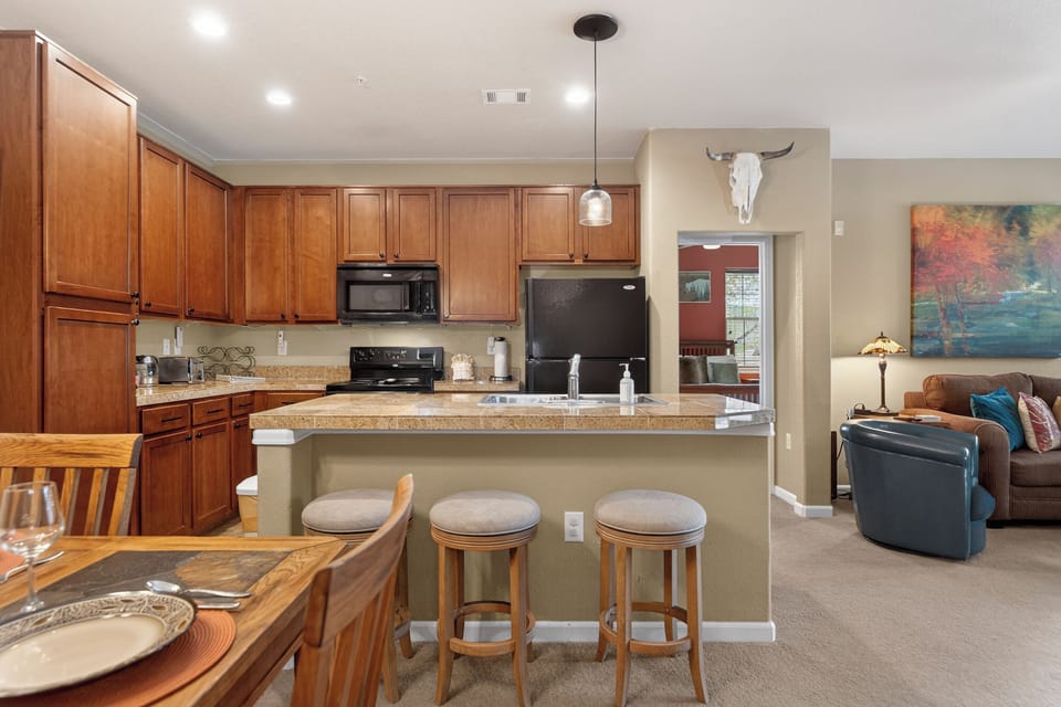 Gather around the spacious kitchen island with granite counters, warm wood cabinetry, and modern appliances—your home base for cooking, conversations, and memorable meals together.