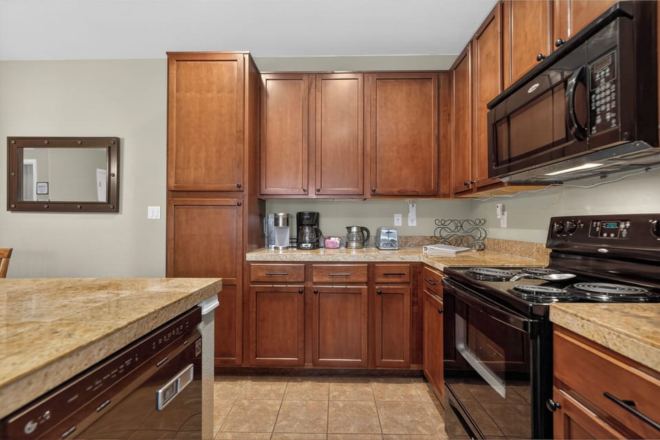 Your fully equipped kitchen features warm wood cabinetry, granite countertops, modern appliances, and everything you need to prepare meals in comfort during your stay.