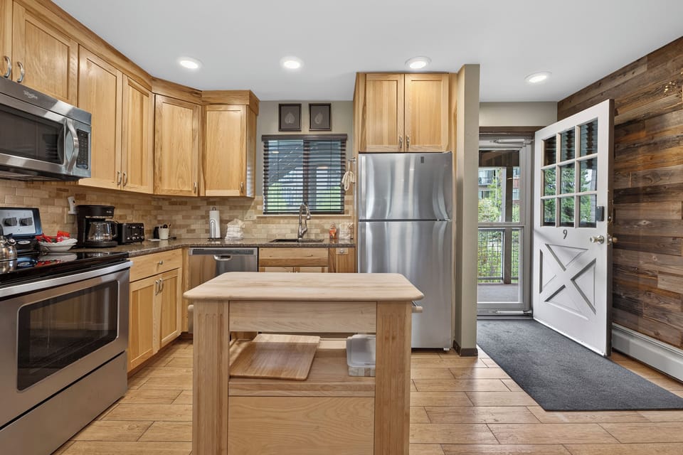 Your modern kitchen features warm wood tones, stainless steel appliances, and a charming barn door entrance. Granite counters and a center island provide plenty of prep space for cooking your favorite meals.