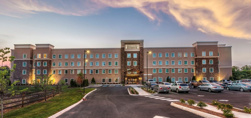 Sunset view of the front entrance, with landscaped grounds and generous parking just outside