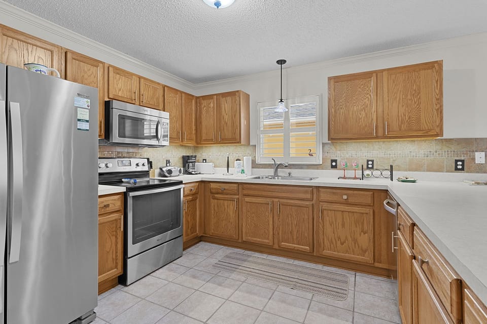 Step into your fully equipped kitchen with modern appliances, ample counter space, and warm oak cabinetry—perfect for preparing home-cooked meals during your stay.