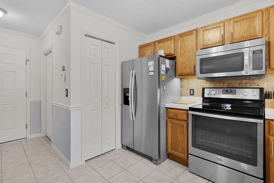Your kitchen is fully equipped with modern appliances, warm wood cabinetry, and everything you need to prepare meals during your stay.