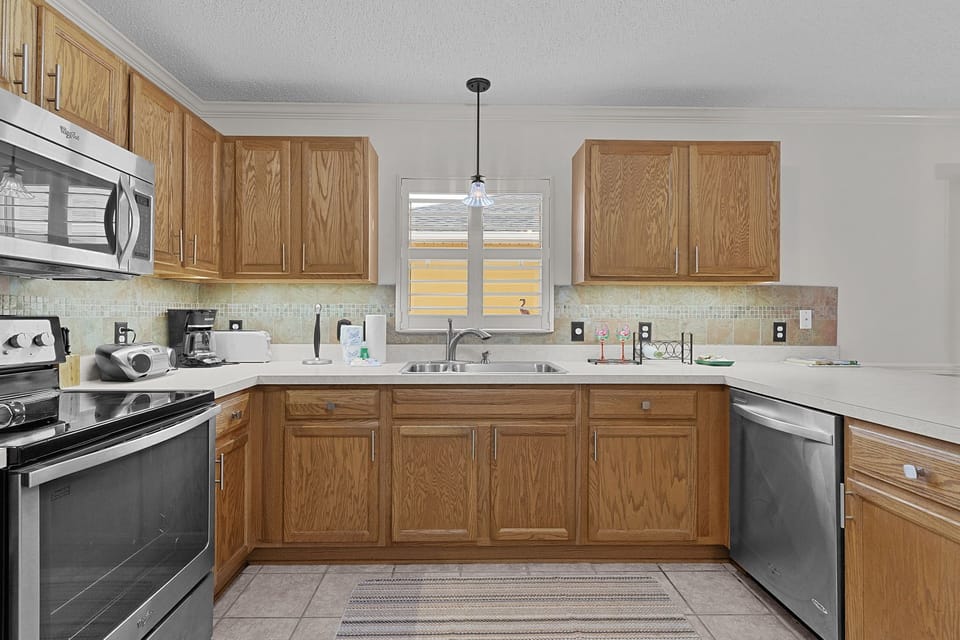 A fully-equipped kitchen with oak cabinetry, modern appliances, and ample counter space for preparing your favorite meals during your stay.