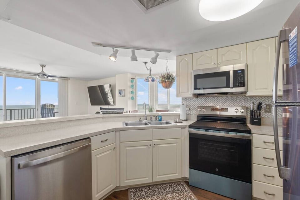 Loaded kitchen at The Pinnacle North Myrtle Beach Unit 506 features stainless steel appliances, full cooking essentials, and beautiful ocean views from the open-concept space.