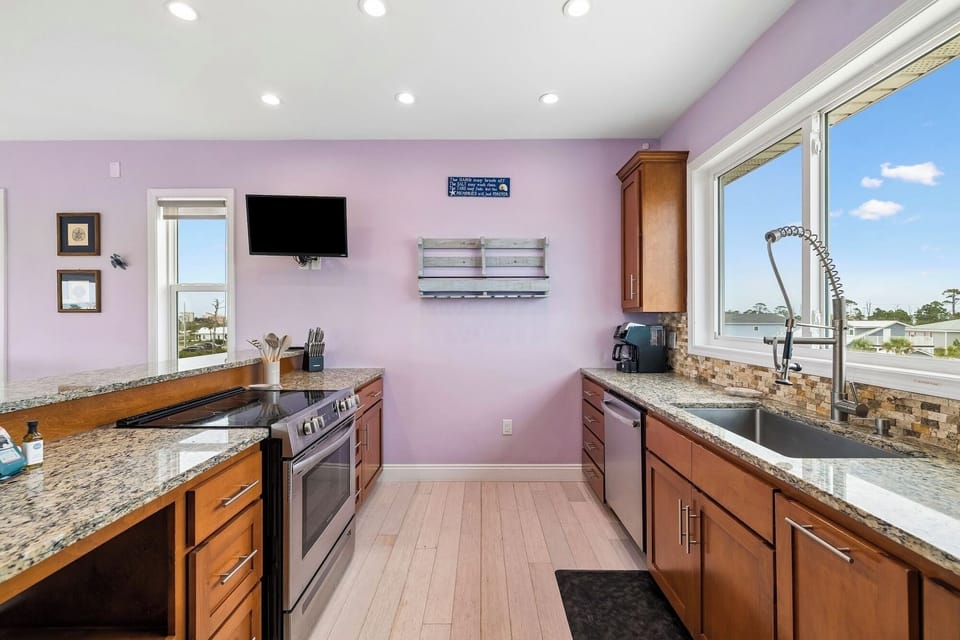 Your fully-equipped kitchen features granite countertops, stainless-steel appliances, and a warm ambiance with soft lavender walls. Enjoy morning coffee at the breakfast bar while soaking in the sunny views.