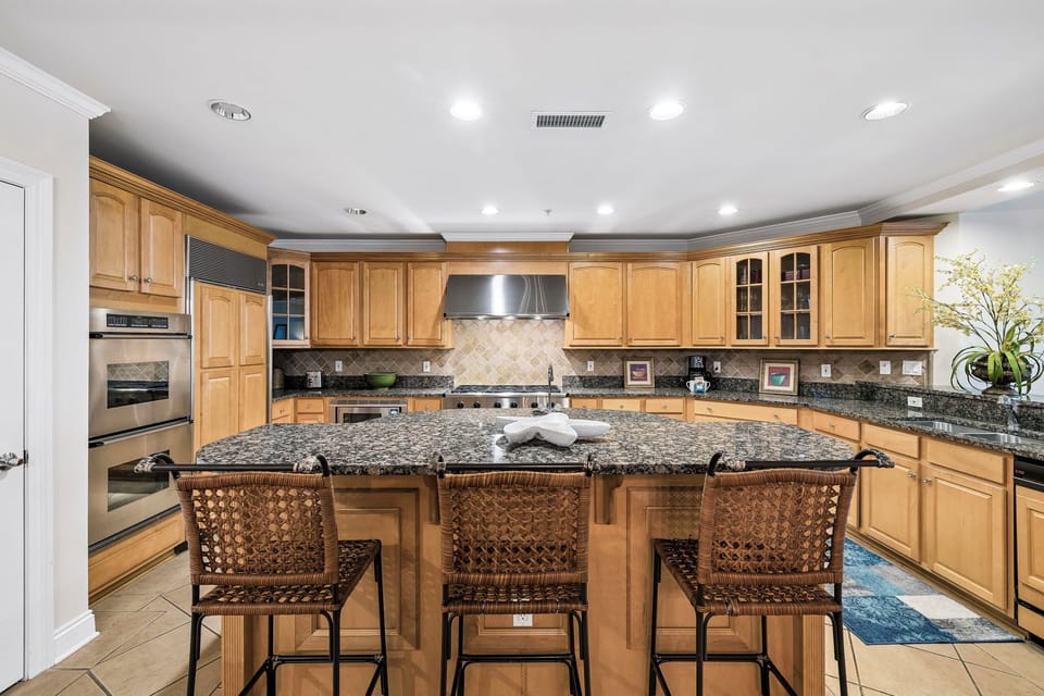 Picture yourself whipping up breakfast at this gorgeous granite island or prepping meals with top-tier appliances. Warm wood cabinetry and abundant counter space create a chef's dream retreat.