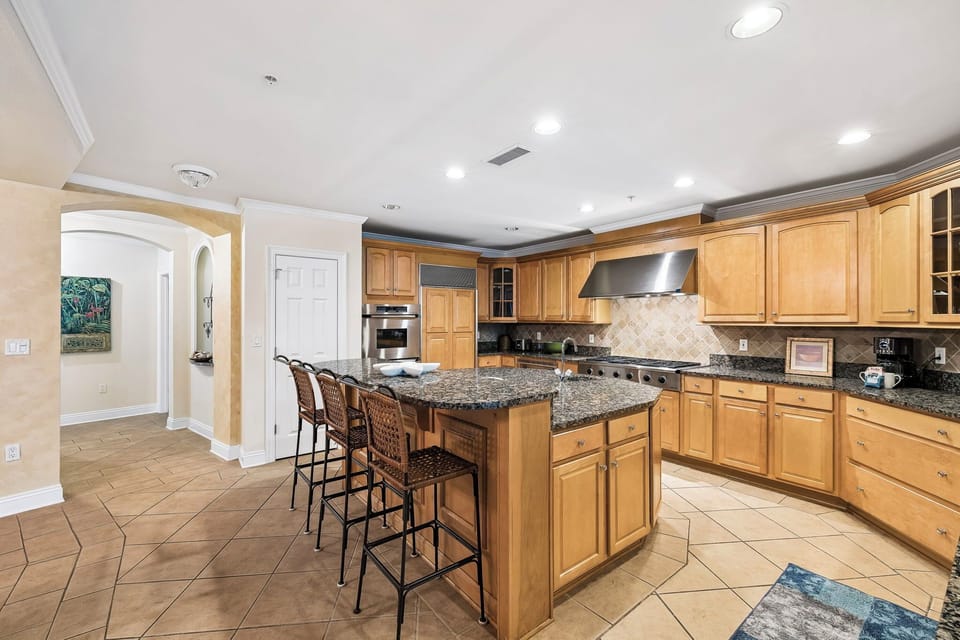 Your gourmet kitchen awaits with rich wood cabinetry, granite countertops, and a spacious island perfect for gathering, cooking, and creating memories together during your stay.