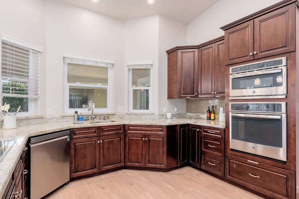 Your fully equipped kitchen awaits with rich cherry cabinetry, gleaming granite counters, and modern stainless appliances—including a double oven—ready to inspire home-cooked meals during your stay.