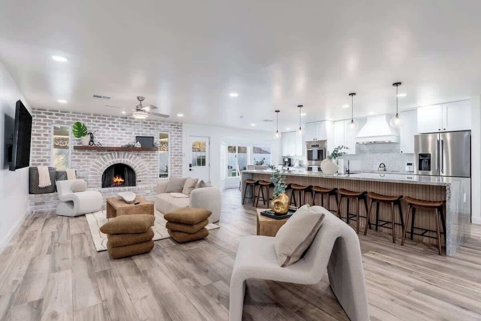 Your open-concept sanctuary blends modern elegance with inviting warmth. Sink into plush seating by the brick fireplace, or gather with friends at the spacious kitchen island beneath stylish pendant lights.