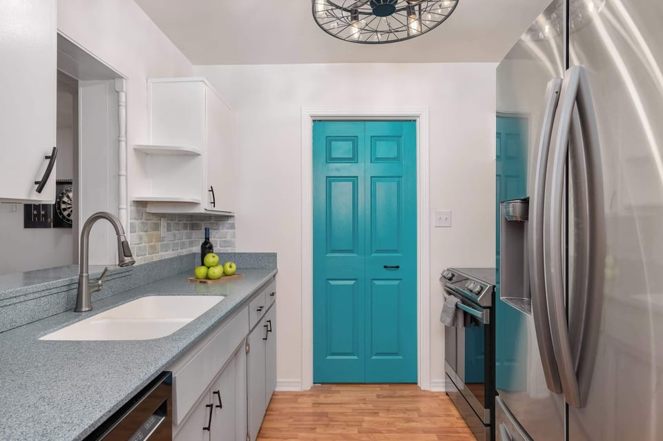 Stylish kitchen w/ teal accent door, stainless appliances & plenty of counter space.
