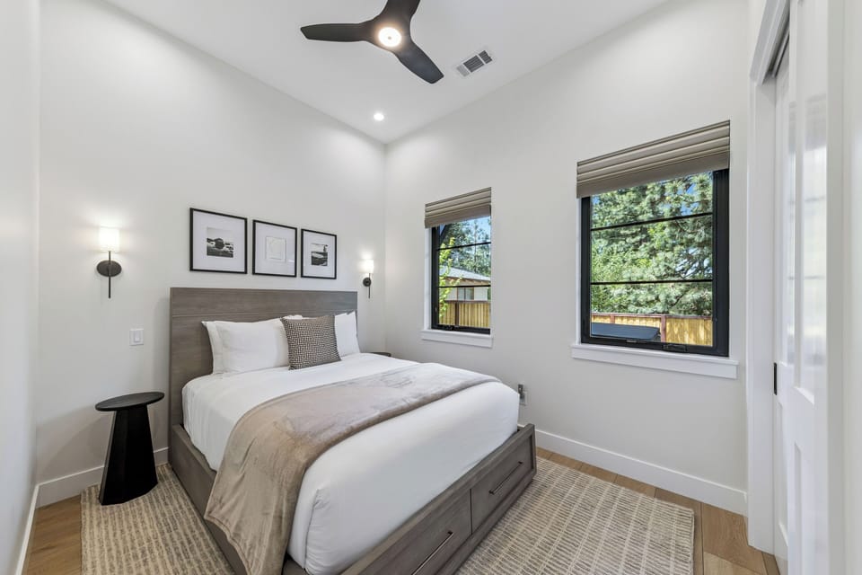 Downstairs bedroom Sink into crisp, white linens and let natural light stream through your private retreat. This serene bedroom offers a peaceful escape where you can recharge and dream.