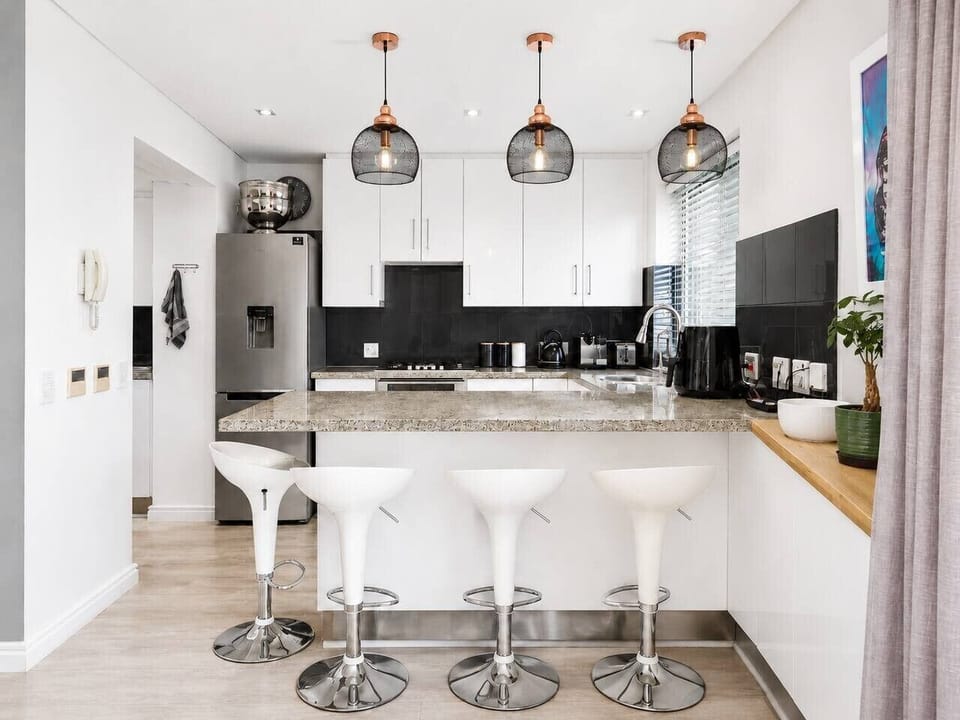 Modern kitchenette with a breakfast bar and stylish finishes, offering a convenient space for preparing meals, enjoying morning coffee, or gathering with friends and family.