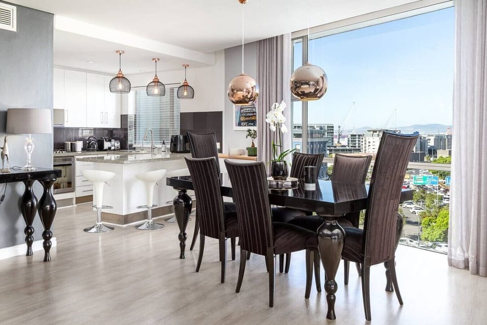 Sophisticated dining area with elegant furnishings, contemporary lighting, and expansive windows that fill the space with natural light and city views.
